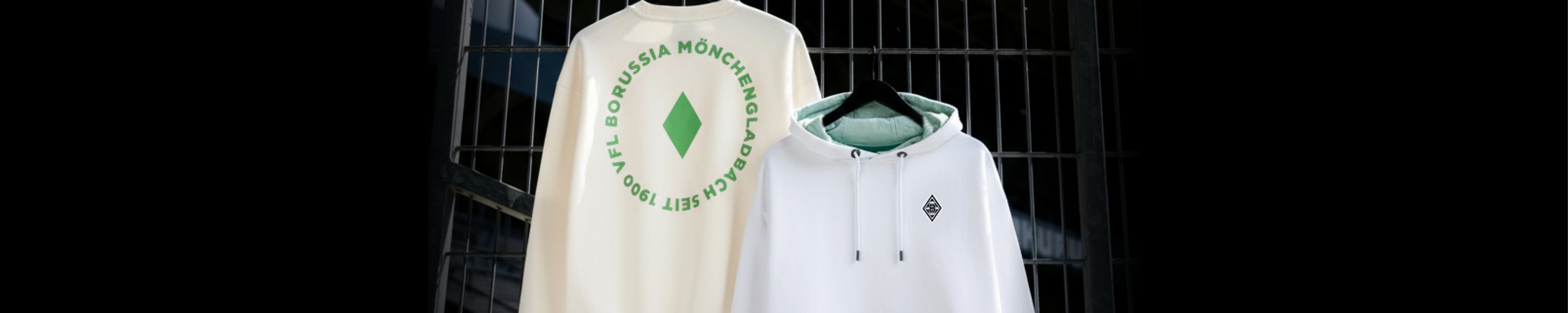 Two Borussia Mönchengladbach hoodies on hangers; one with a circular logo on the back, the other with a small front emblem.