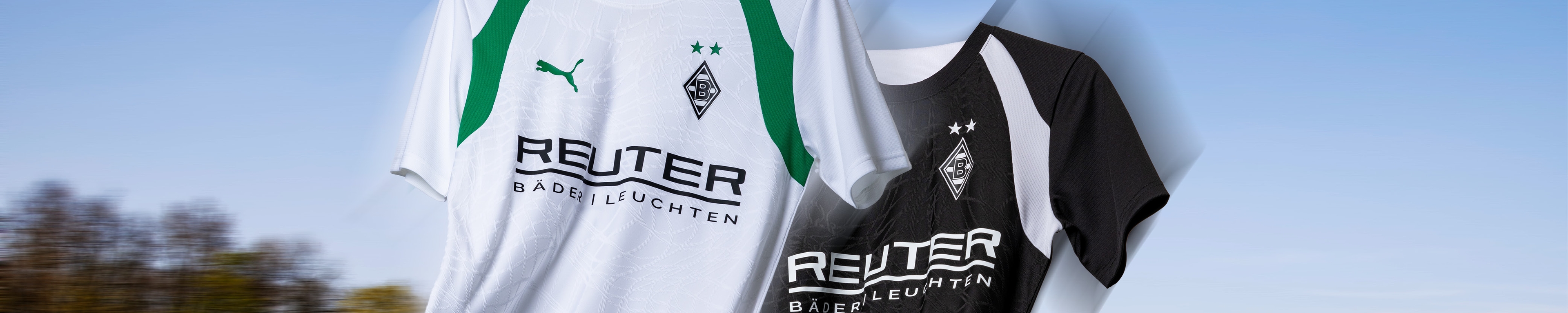 Two soccer jerseys with the Borussia Mönchengladbach logo; one is white with green accents, the other is black with white accents, both have the same sponsor.