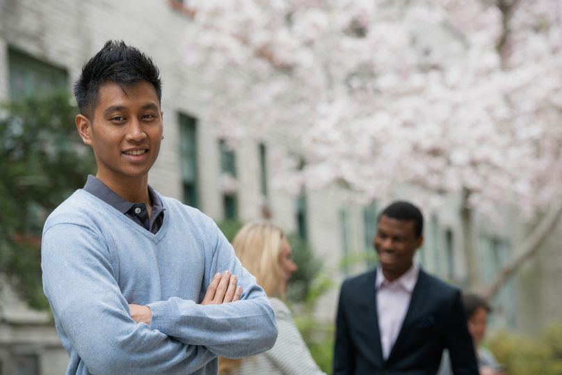 Young Man Smiling with People in the Background