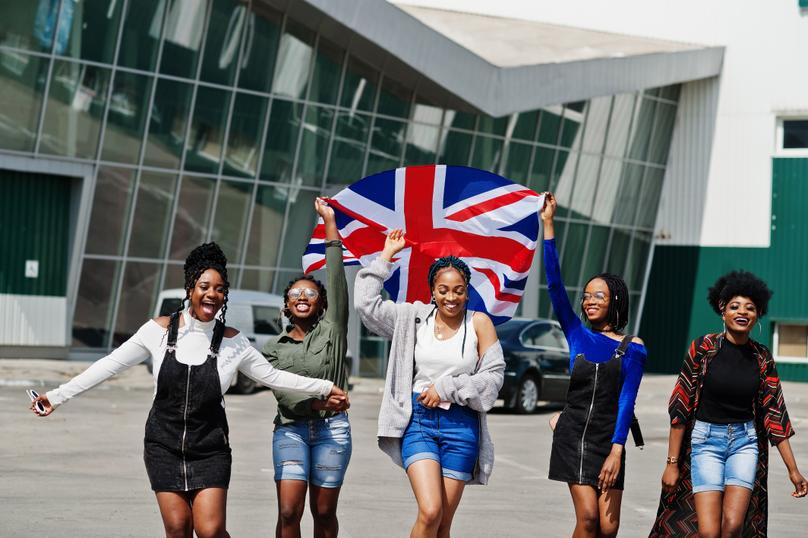 Group of five african women walking together with UK flag.