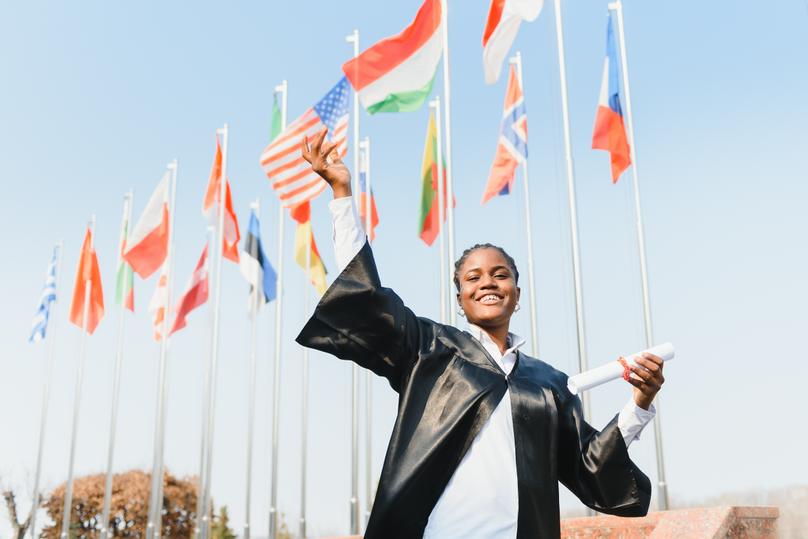 cheerful african american graduate student with diploma in her hand