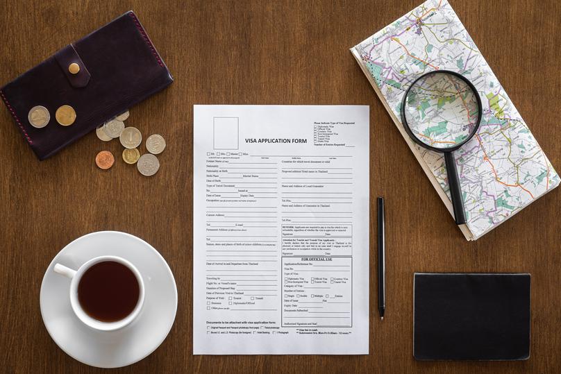 Visa application form on a wooden table, visa processing, registration, flat lay