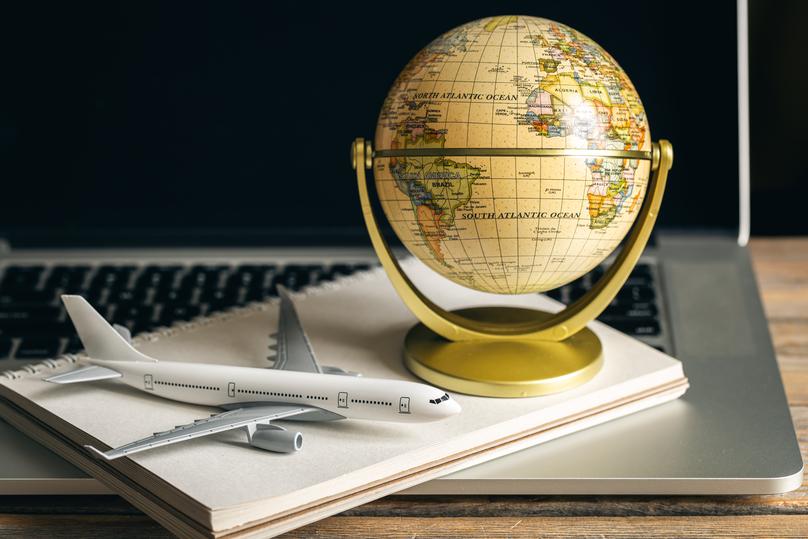 model of an airplane and a globe on a wooden table