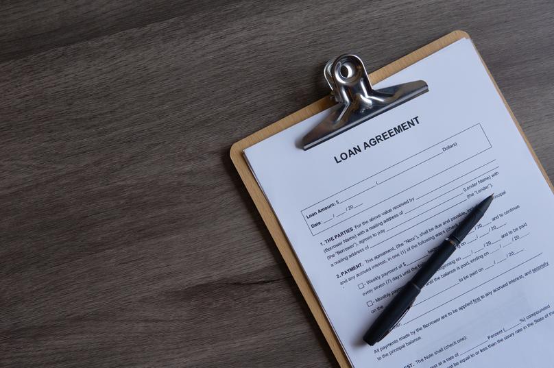 Loan Agreement Ready for Signing on Wooden Desk