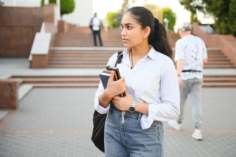 Portrait of Indian girl student with books near university