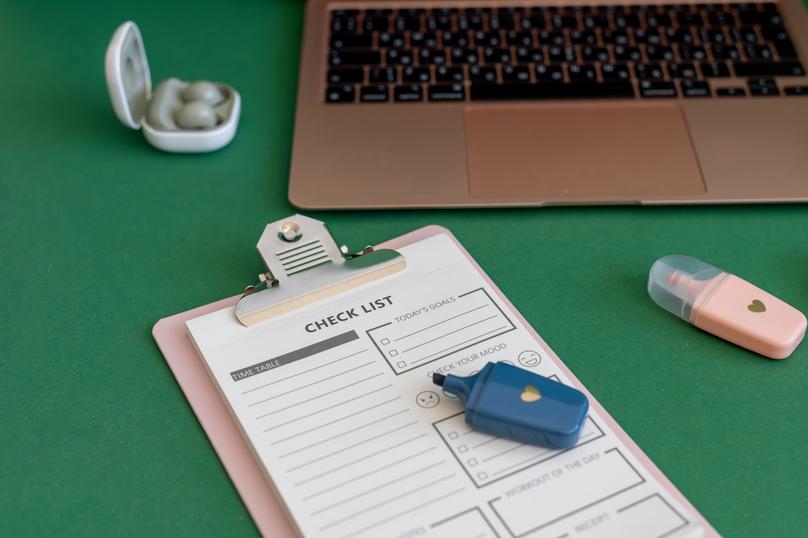Colorful school supplies on a green background