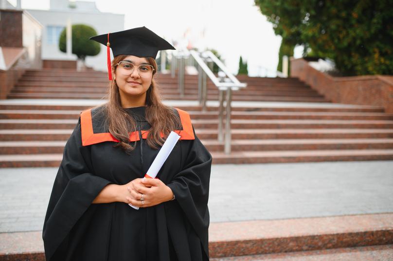Indian university student graduating holding diploma