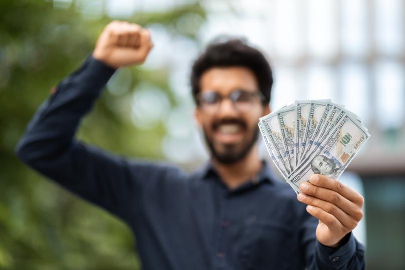 Excited Man Holding Money Outside Office Building