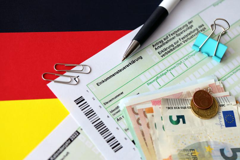 German income tax return form with pen and european euro money bills