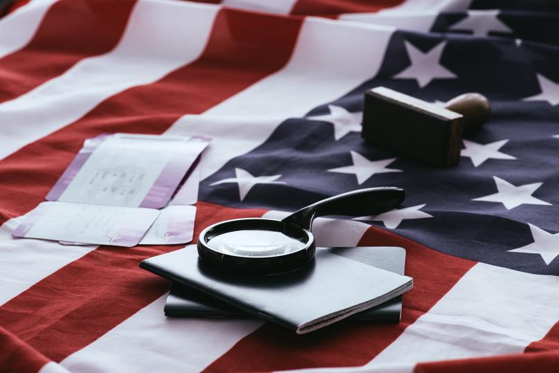 selective focus of passports and magnifier near tickets and american flag