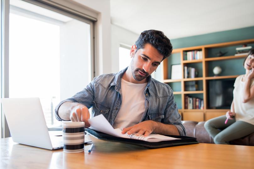 Man Working at Home with Laptop and Papers