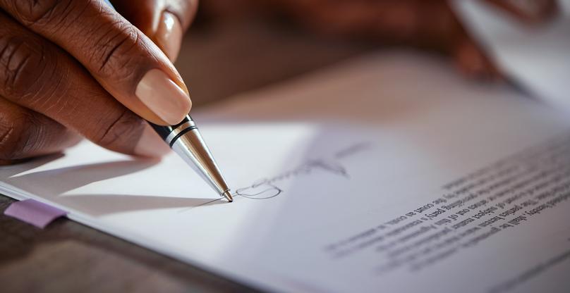 Detail of woman hands signing business document