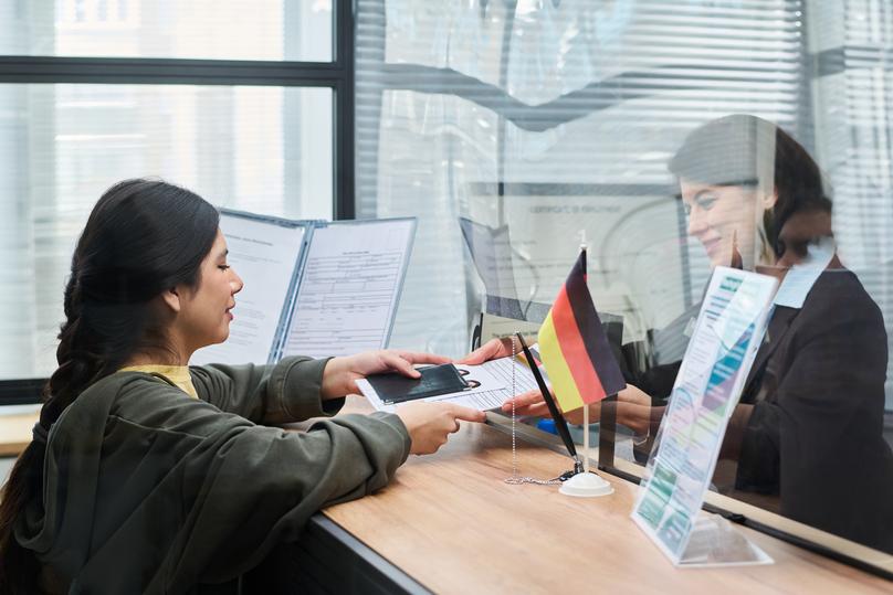 Young Adult Woman Submitting Passport Documents at Visa Center Counter