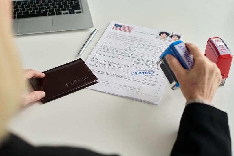 Close up of immigration office worker approving visa application