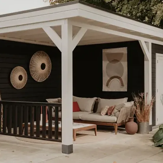 Houten buitenverblijf ingericht met loungebank en opbergruimte