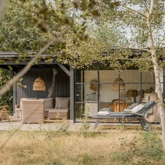 Houten buitenverblijf met industriële glazenschuifwand