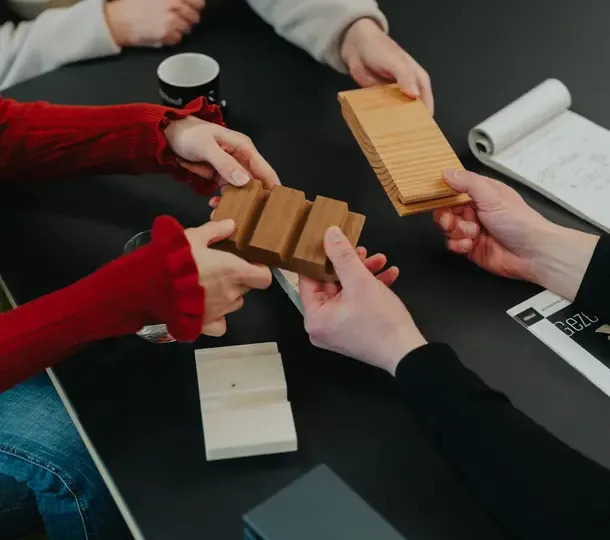 5 handen voelen aan twee houten blokjes