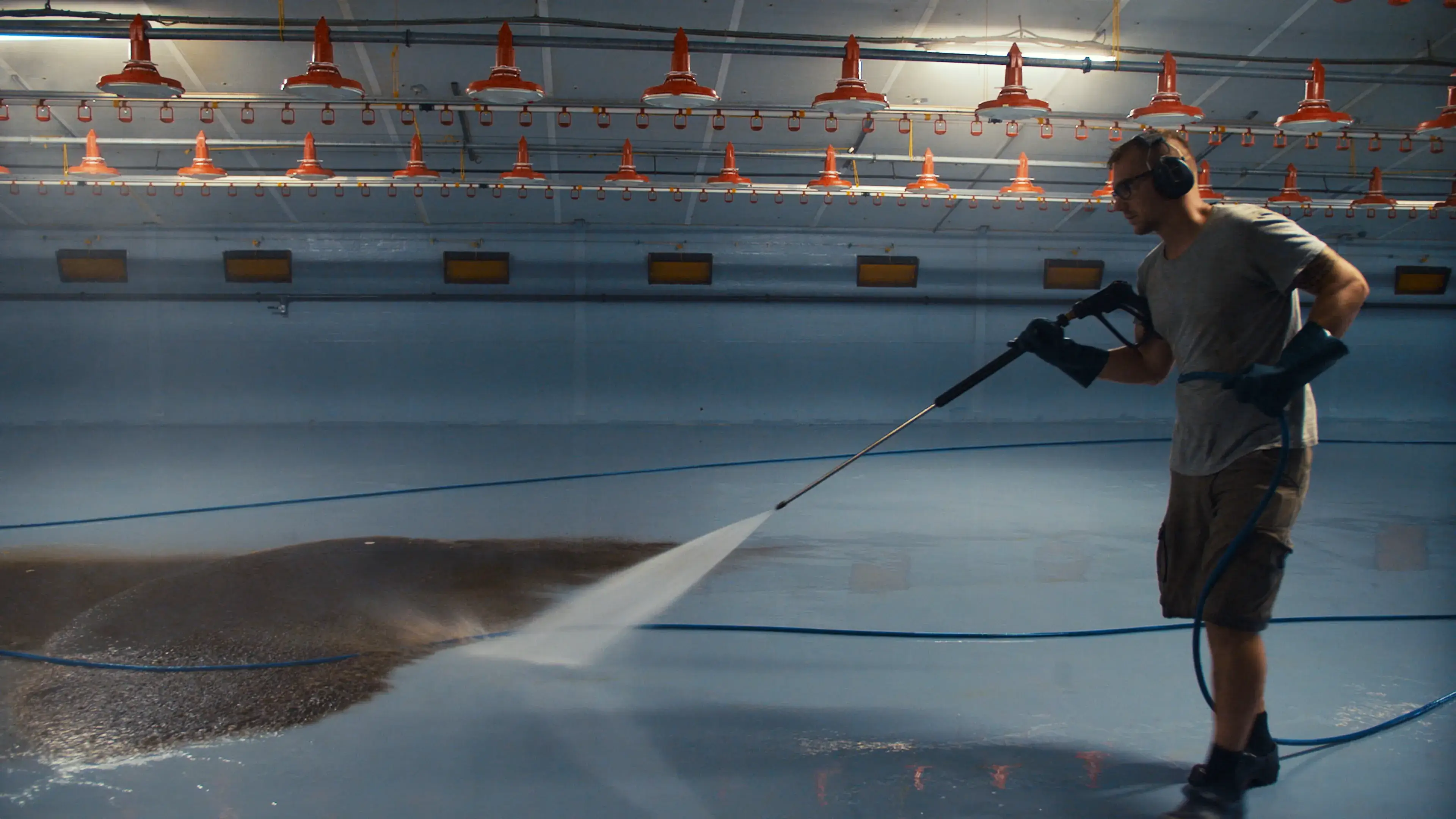 Rinsing the poultry barn with a high pressure washer after cleaning with MS TopFoam