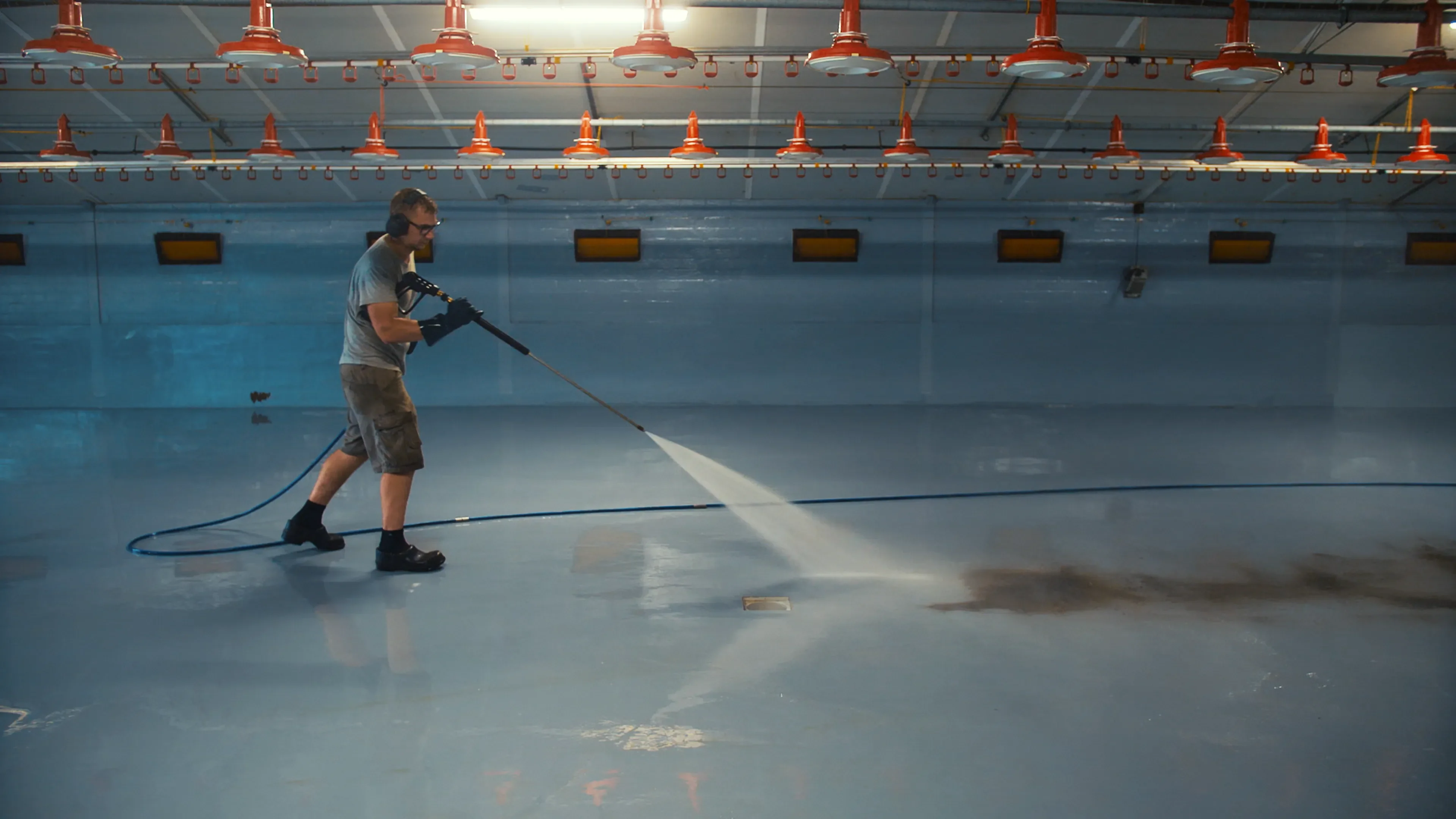 Rinsing the lose contamination from the floor in a poultry barn after cleaning with MS TopFoam