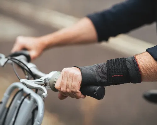 Handgelenk mit Bandage eines älteren Mannes, der ein Fahrradlenkrad festhält