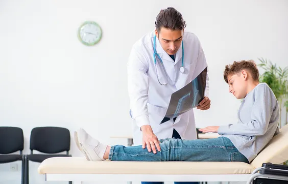 Parese, betroffener Jugendlicher bei Untersuchung mit Arzt, Bewegungseinschränkung, unvollständige Lähmung der Skelettmuskulatur