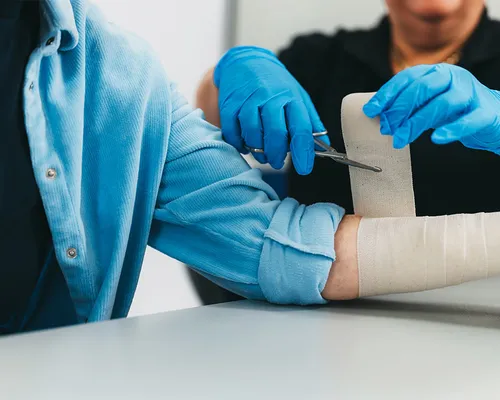 Mann mit Wundheilungsstörung, Wunde wird versorgt von Arzt mit Verband