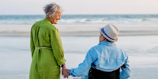 Frau mit Mann im UHC Reise-Rollator Easy GT am Strand