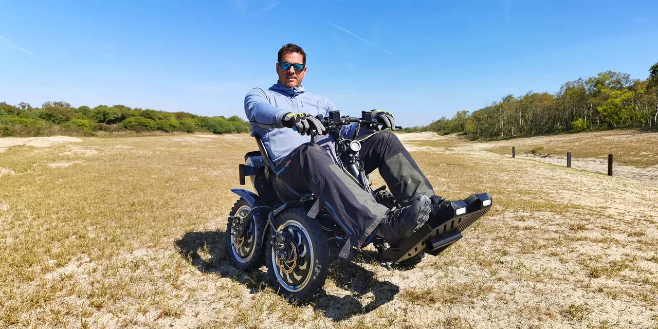 Mann im Rollstuhl auf einer Naturlandschaft