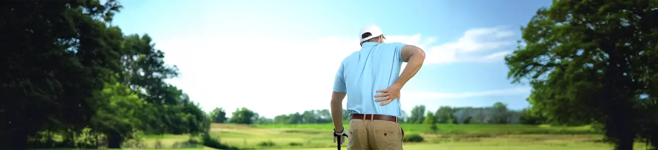Spinalkanalstenose, Mann beim Golfen, greift sich an unteren Rücken