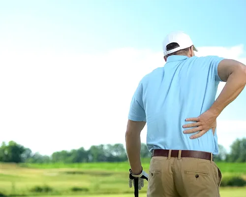 Spinalkanalstenose, Mann beim Golfen, greift sich an unteren Rücken