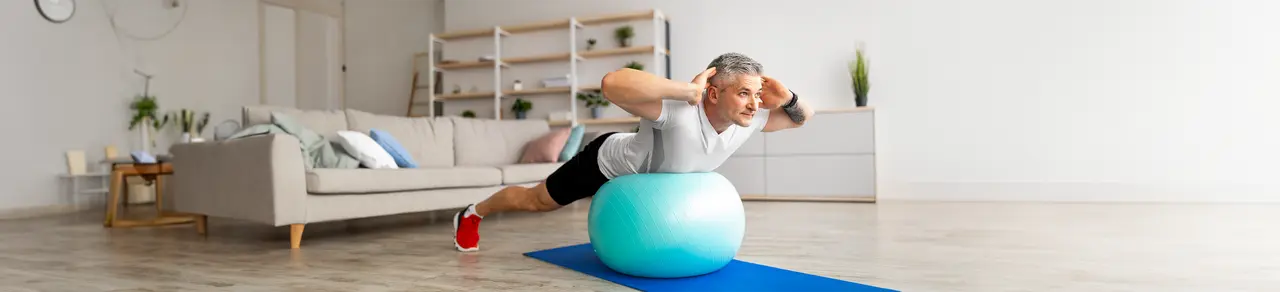 Bandscheibenvorfall, Mann macht Übung auf Gymnastikball, Rückentraining