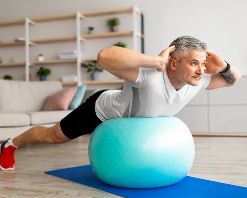 Bandscheibenvorfall, Mann macht Übung auf Gymnastikball, Rückentraining