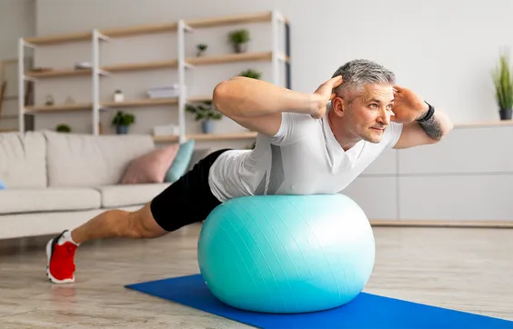 Bandscheibenvorfall, Mann macht Übung auf Gymnastikball, Rückentraining