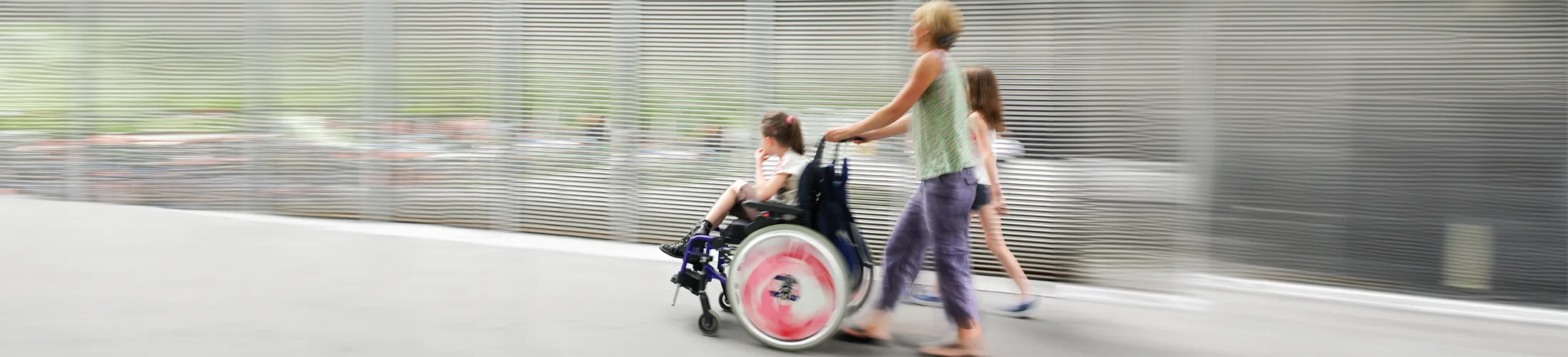 Kinderlähmung, Kind im Rollstuhl mit Mutter und Schwester, Mobilität, individuell angepasster Rollstuhl