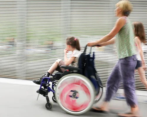 Kinderlähmung, Kind im Rollstuhl mit Mutter und Schwester, Mobilität, individuell angepasster Rollstuhl