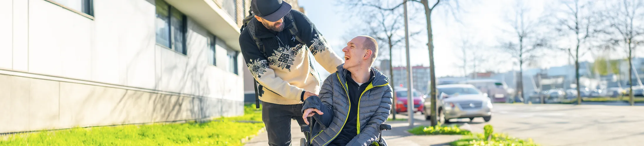ALS, Patient im Rollstuhl mit Angehörigem, fortschreitende Lähmungen, unkontrollierte Muskelspannung