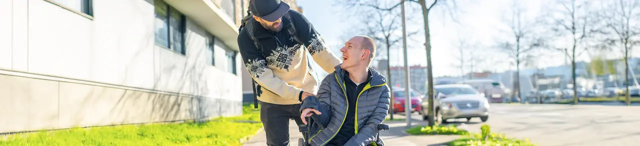 ALS, Patient im Rollstuhl mit Angehörigem, fortschreitende Lähmungen, unkontrollierte Muskelspannung