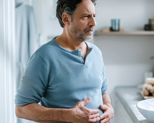 Stomabeutel wechseln, Mann fasst sich an Bauch, drei Mal täglich wechseln, Hygiene wichtig