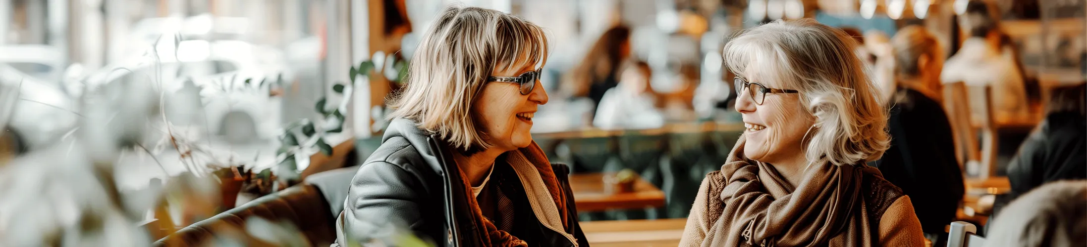 Inkontinenz in den Wechseljahren, zwei ältere Frauen sitzen im Café und tauschen sich aus