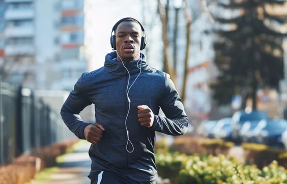 Meniskusrissbehandlung, junger Mann joggt, trägt Orthese