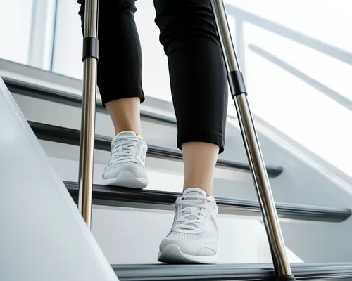 Person läuft mit Krücken die Treppe herunter, auf Bild sind nur die Beine und Füße zu sehen, Schattenwurf an der Wand im Hintergrund