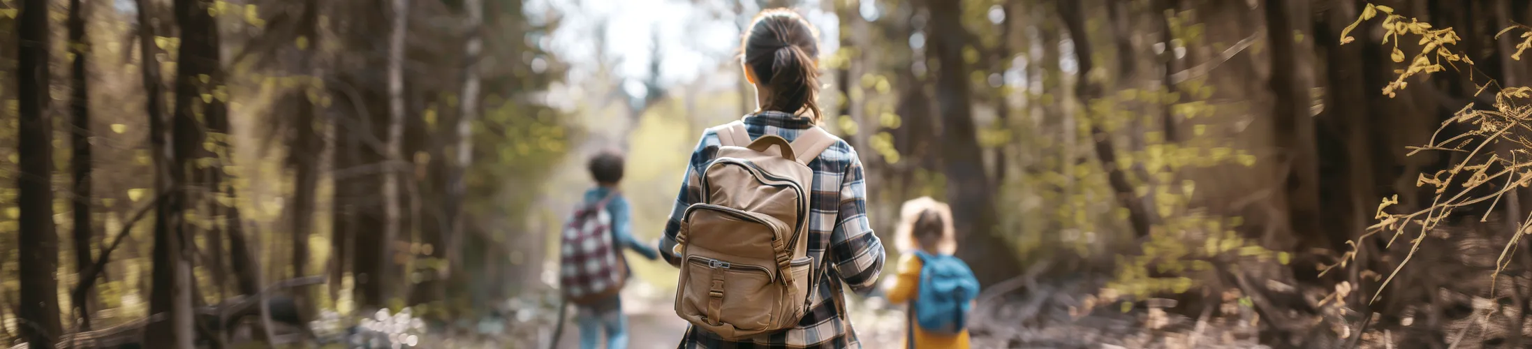 Frau mit Kolostoma beim Wandern mit ihren zwei Kindern im Wald