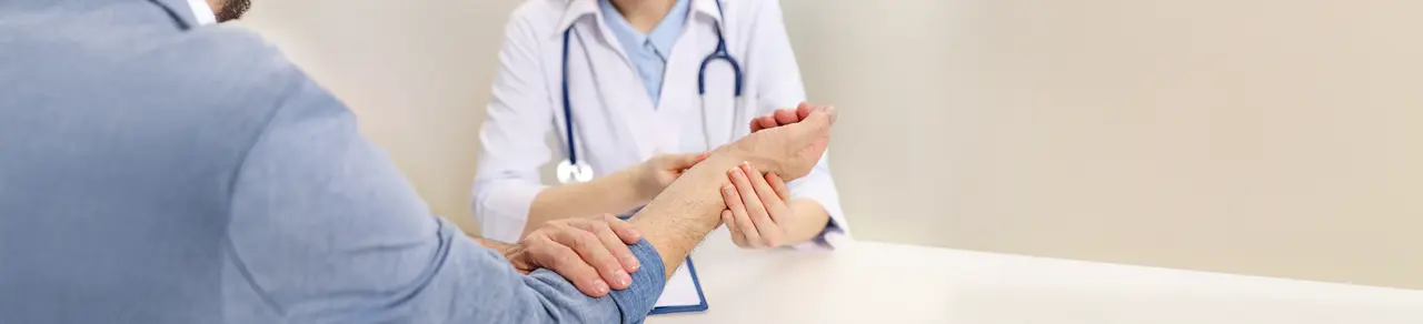 Fallhand, Ärztin untersucht das betroffene Handgelenk, Fallhand-Therapie