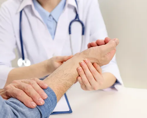 Fallhand, Ärztin untersucht das betroffene Handgelenk, Fallhand-Therapie