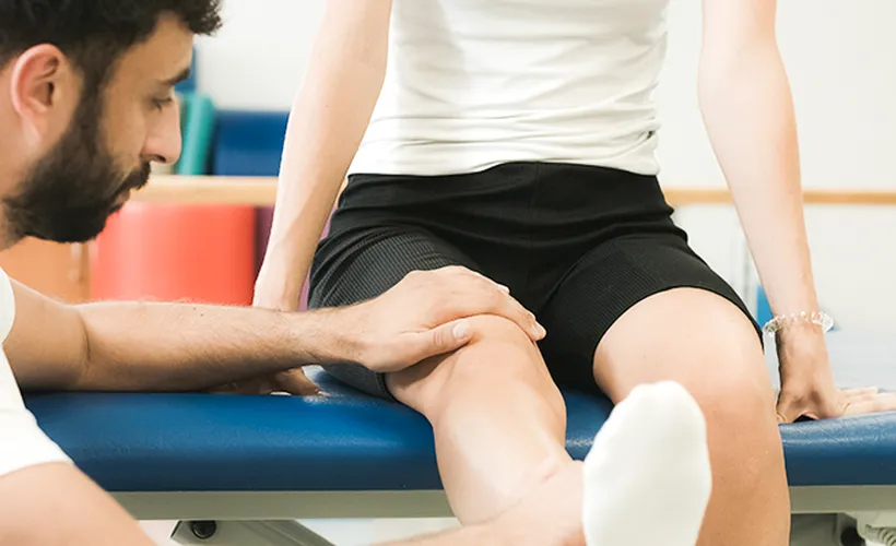 Thromboseprophylaxe, Therapeut lagert Bein von Betroffenem hoch, Blutgerinnsel vorbeugen