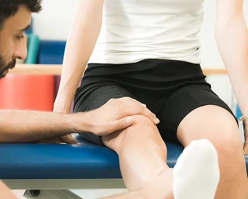 Thromboseprophylaxe, Therapeut lagert Bein von Betroffenem hoch, Blutgerinnsel vorbeugen