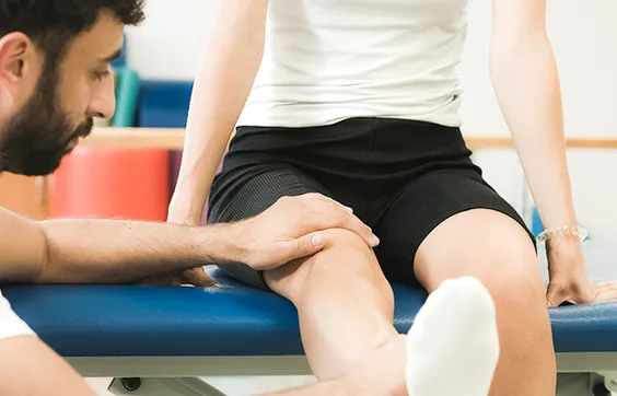 Thromboseprophylaxe, Therapeut lagert Bein von Betroffenem hoch, Blutgerinnsel vorbeugen