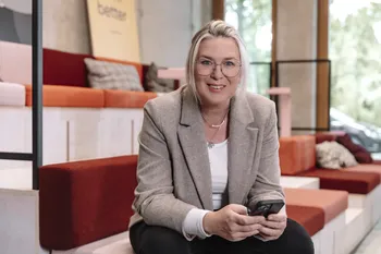 Isabel Feys, COO bei joviva, hält ein Smartphone in den Händen, schaut in die Kamera