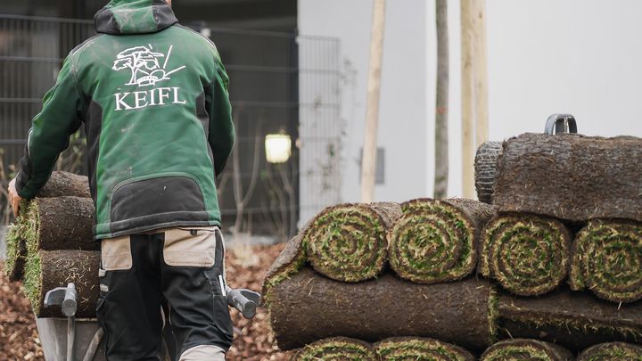 Keifl-Gärtner neben gestapeltem Rollrasen