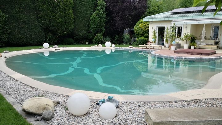 Runder Pool in einem Garten mit Kiesumrandung